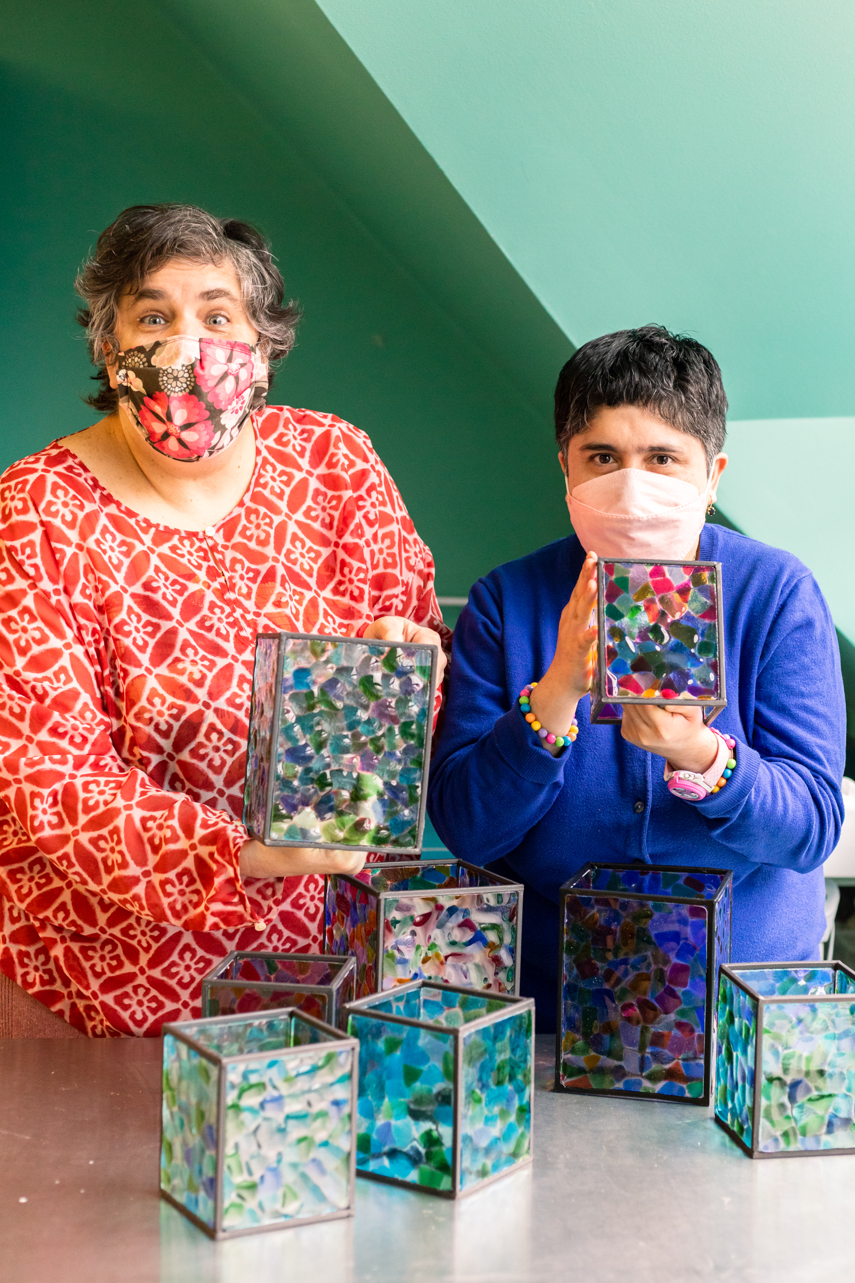 Adult program participants showing off their glass projects