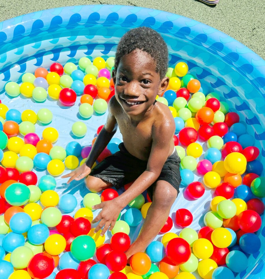 kid in a pool with plastic balls